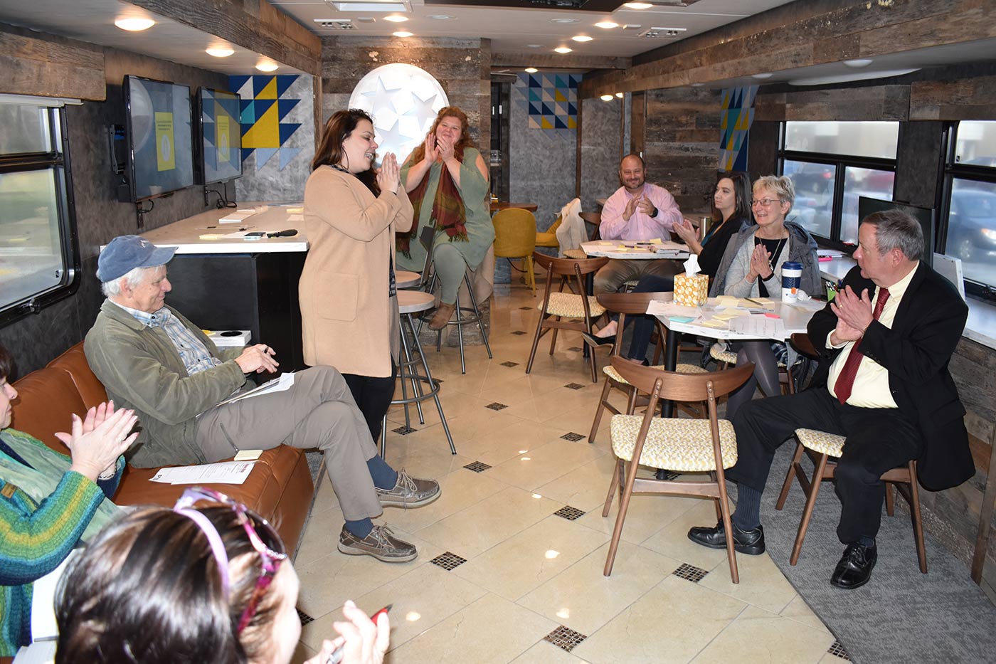 Attendees at a workshop for business owners and aspiring entrepreneurs applaud following a presentation inside a state-funded bus parked outside the Cumberland Business Incubator.