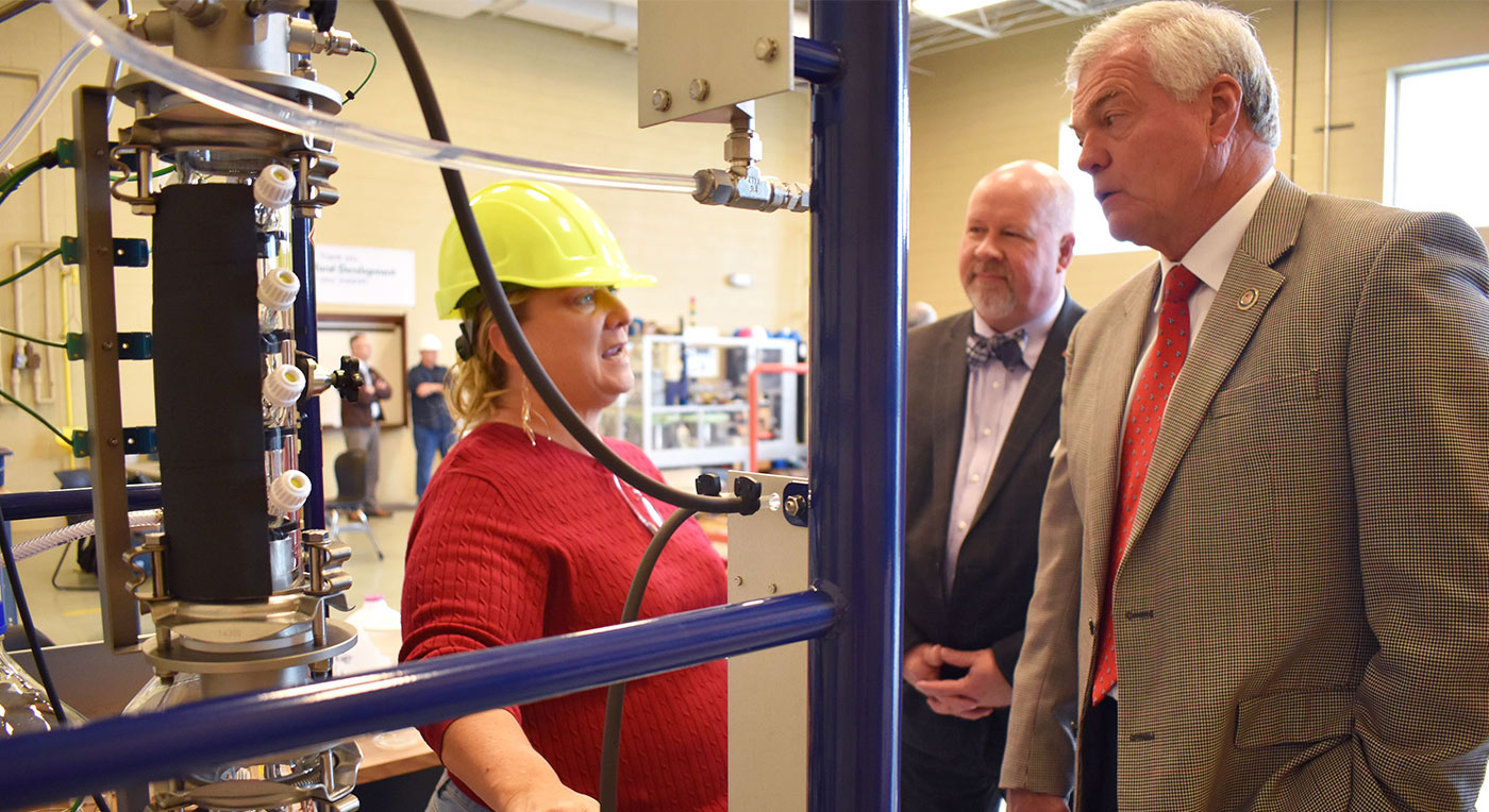 Teresa Kovalcson talks with Jim Tracy, director of USDA’s Tennessee Rural Development Office, while Roane State President Chris Whaley listens in background. A USDA Rural Development grant paid for the chemical engineering technology equipment shown in foreground.