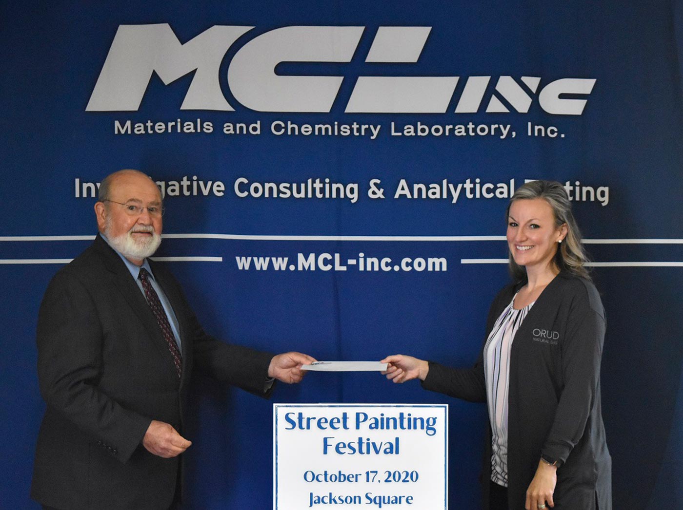 (Photo provided by MCLinc): MCLinc President and CEO Barry Stephenson hands Nikki Adkisson, community service chair for the Rotary Club of Oak Ridge, a check for a Platinum Sponsorship of the Oak Ridge Street Painting Festival.