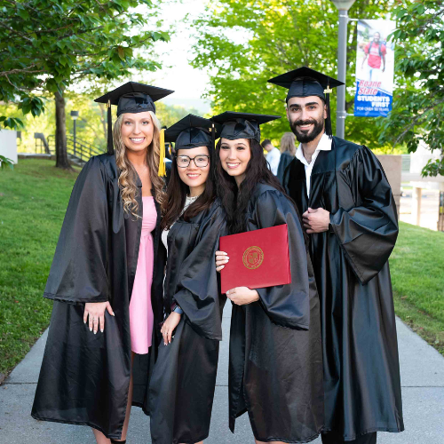 Four people wearing graduation attire.