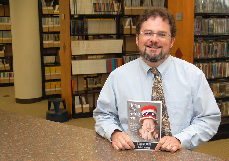 Robert Benson, Roane State director of library services, accepts a copy of  “Fighting at the Fertility Front” donated by author and Roane State graduate Dr. E. Scott Sills.