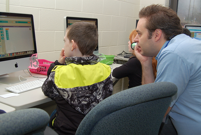 Roane State webmaster Jeremy Pulcifer mentors second-graders during Hour of Code at Glenwood Elementary School.