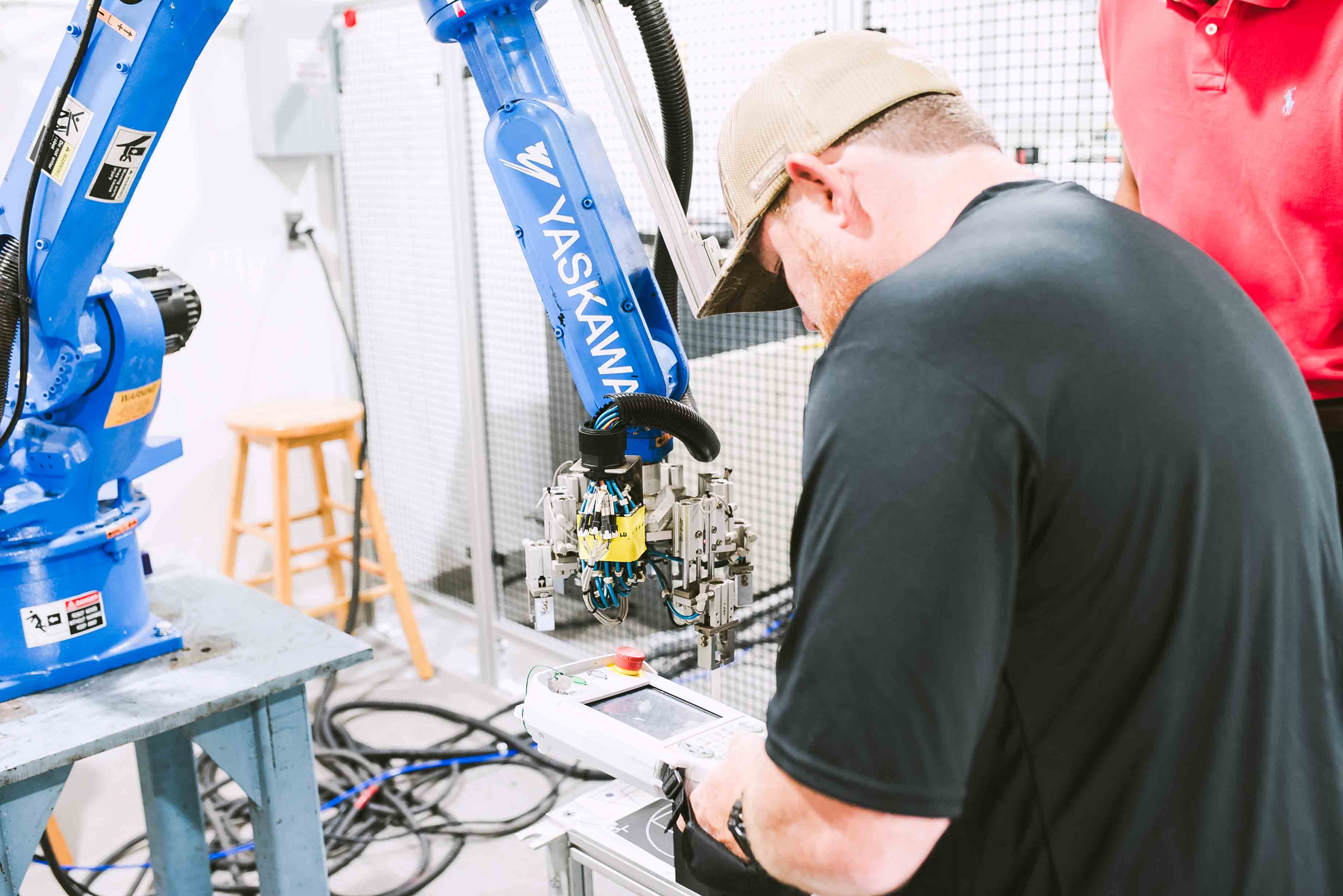 Student working on robotics manufacturing equipment