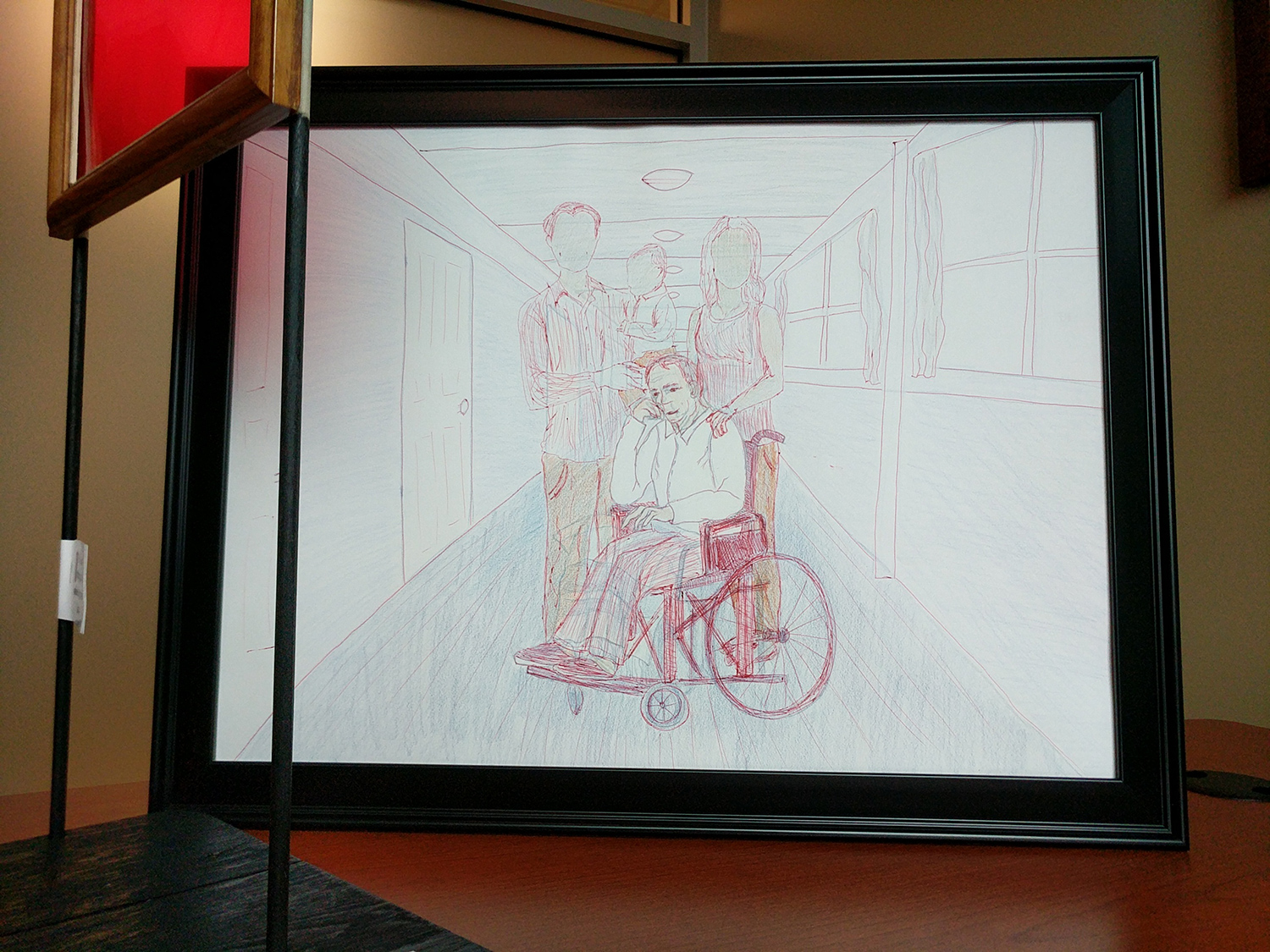 Drawing of a perspective hallway. The focus is of a fully drawn individual sitting in a wheelchair. Behind the wheelchair are three individuals that appear to be a man, woman and child, however their faces are blank.