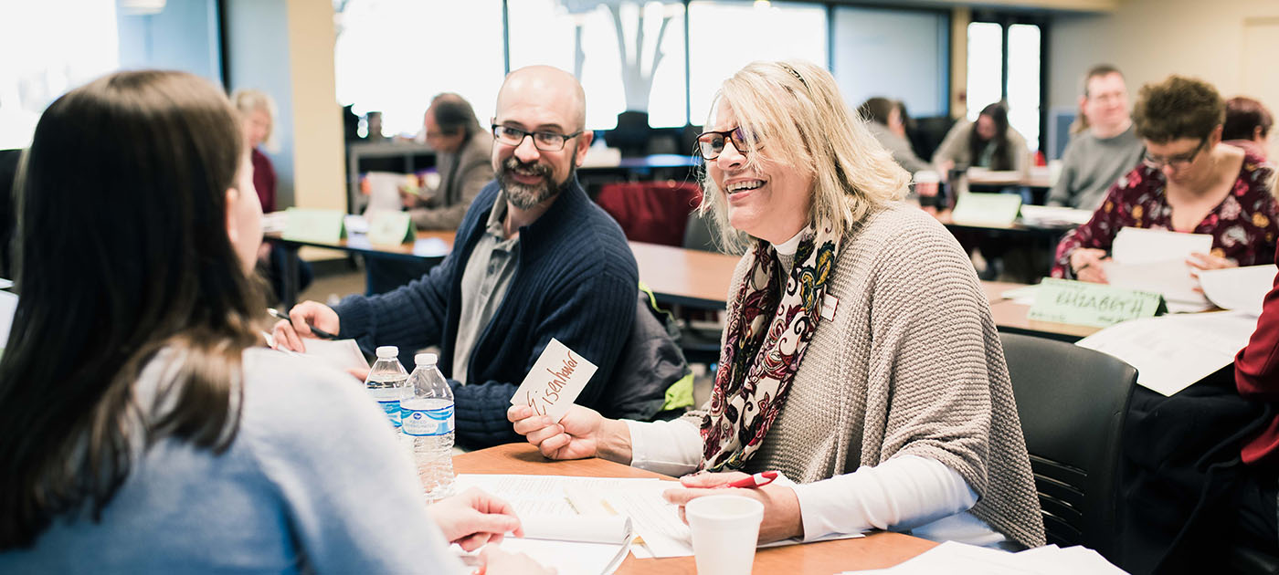 Banner image of faculty and staff in a classroom environment