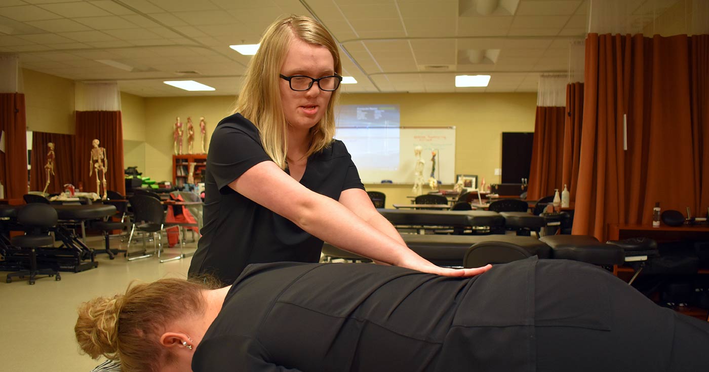 Blind since she was 6, Harley Sharpe practices massage on another of the students in a massage therapy class.