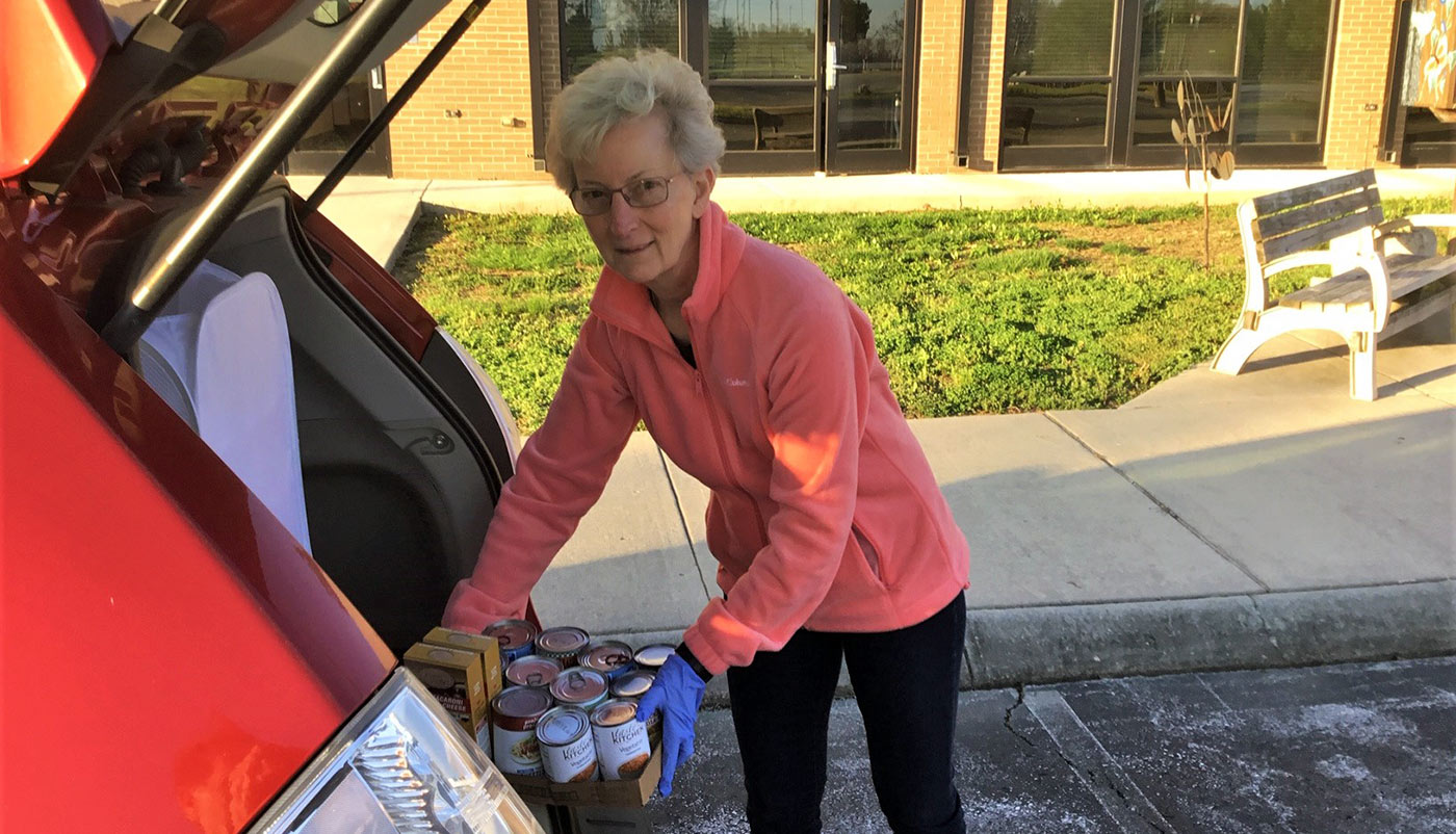 Holly Hanson loads canned food into a vehichle.