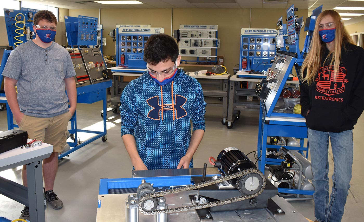 Jeremiah Hamby, a Wartburg Central High student, works on the chain drive mechanism at the Roane State mechatronics lab on the community college’s Roane County campus. Watching are, from left, Luke Jones of Oliver Springs High and Josh Gilmore, a Midway High School student.