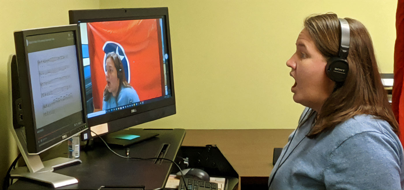 Student singing while looking at a computer