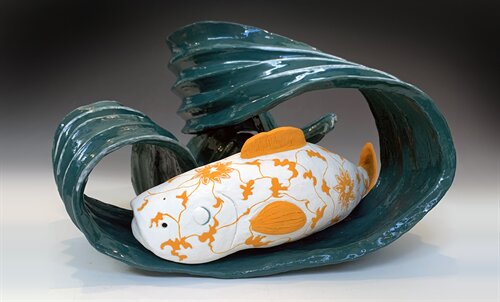 Ceramic artwork of a goldfish within a stylized water wave