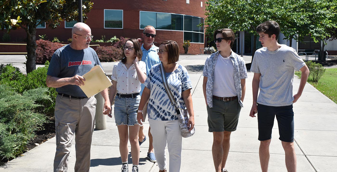 Roane State’s Jack Parker talks with the Dunsmore family during their tour of the Coffey/McNally Building, in background, and the Goff Building on the Oak Ridge Branch Campus. From left: Jack Parker with Megan, Todd and Jennifer Dunsmore, Jacob and Luke.
