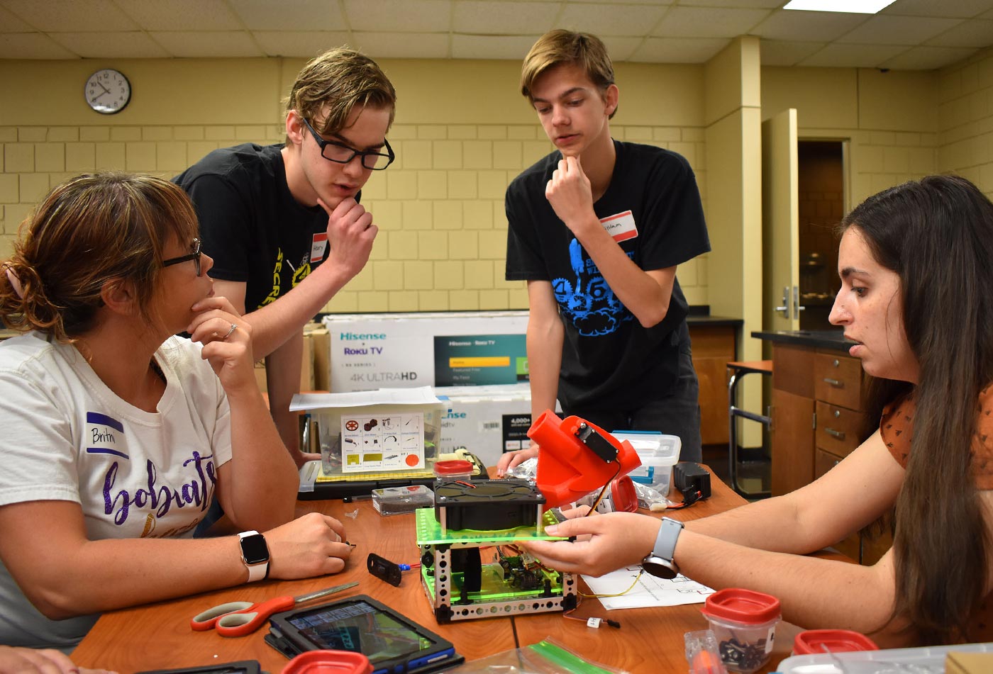 Brothers Henry Kitts, left, and William Kitts help educators Britini Carter, left, and Nicole Hood as they assemble a robotics kit that’s part of the Lab-in-a-Box program administered by Roane State.
