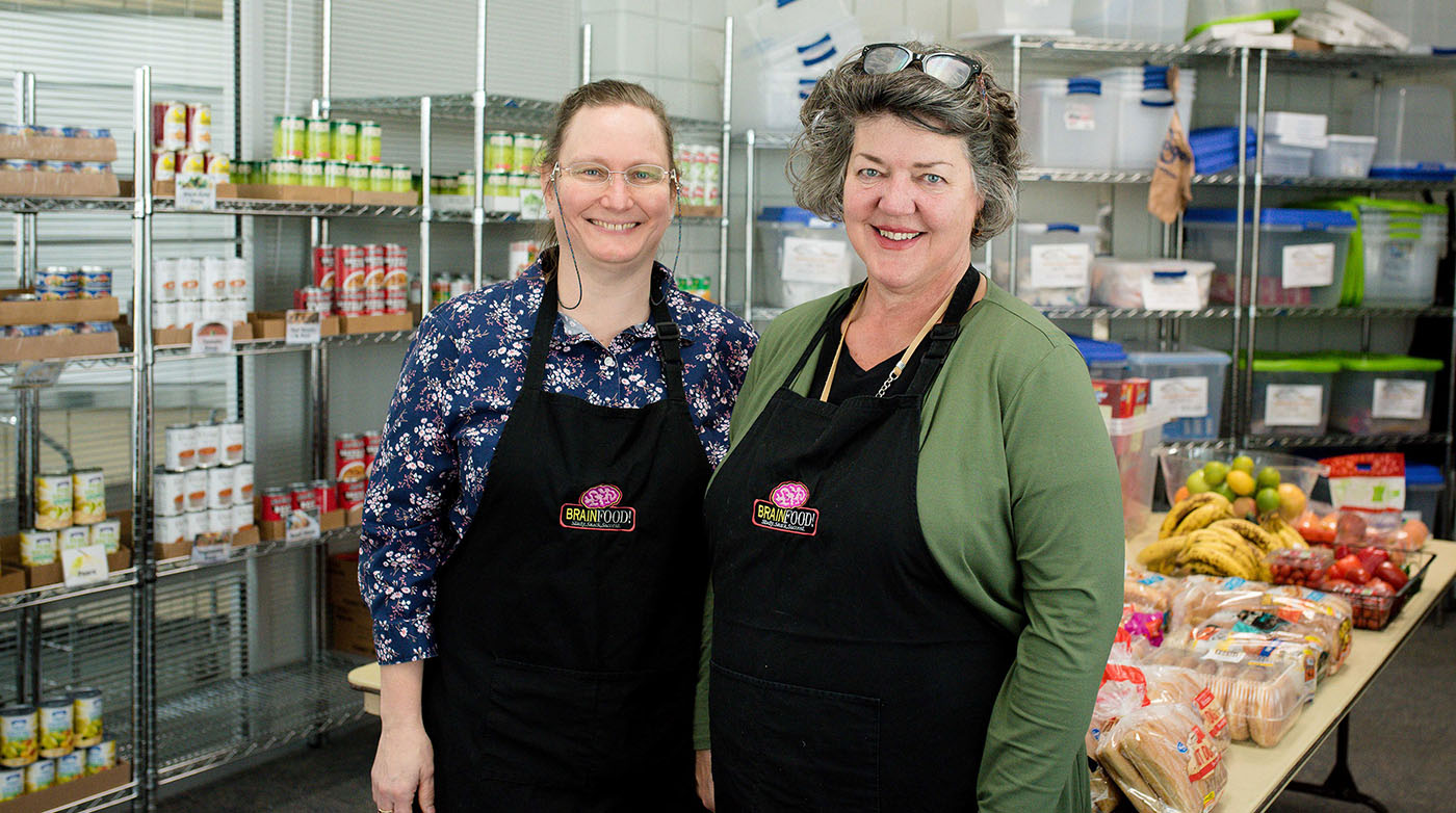 Two staff standing in the food pantry