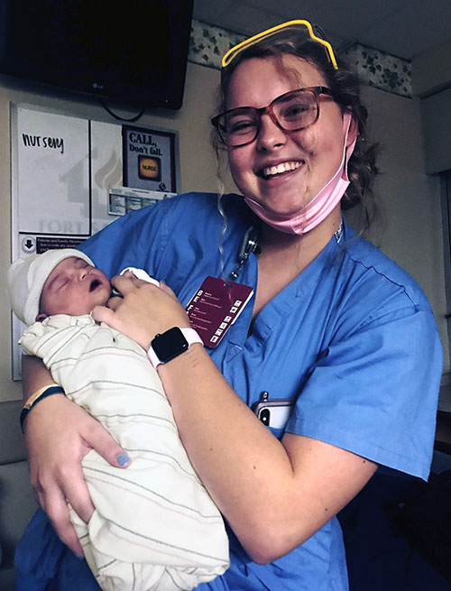 Jana Griffin in a hospital room holding a newborn baby.