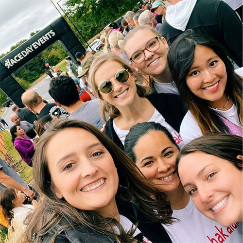 A group of students looking at the camera. A sign saying 'ACEDAYEVENTS' is in the background.