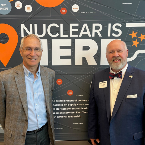 UT-Battelle's Jeff Smith and RSCC President Chris Whaley in front of a background that says "Nuclear is Here."
