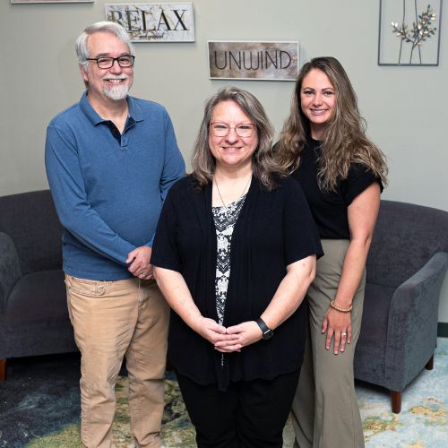 Three people standing in an ofice.