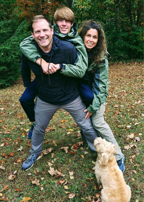 Three people outside with a dog.