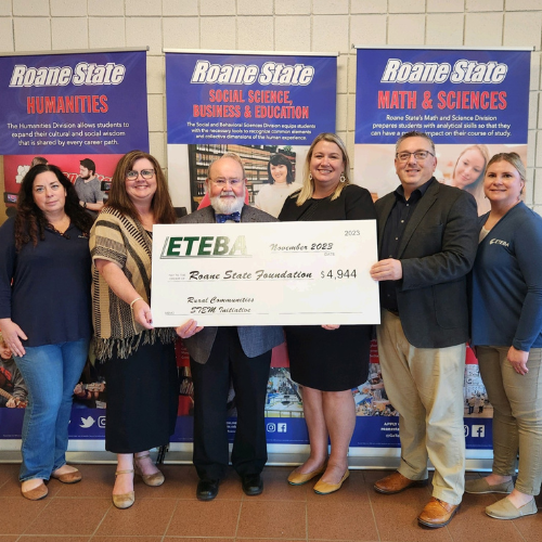 A group of people holding a large check.