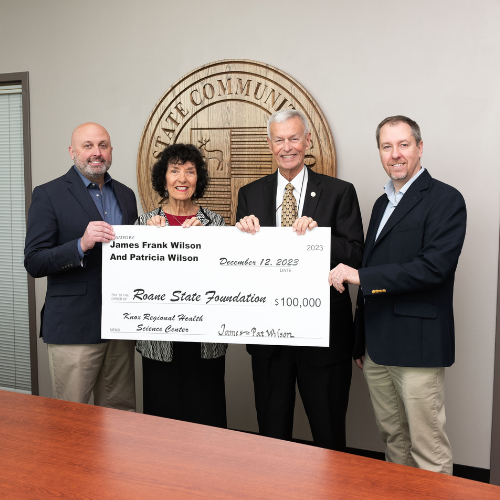 Four people standing with a large check.