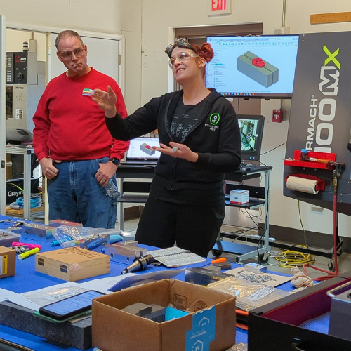 People standing in a classroom with technical equipment and tools.