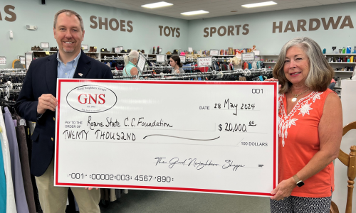 Two people holding a large check.
