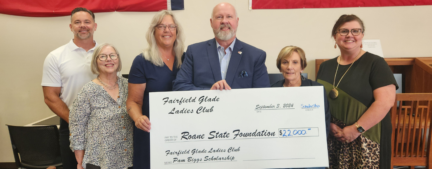 A group of people holding a large check.