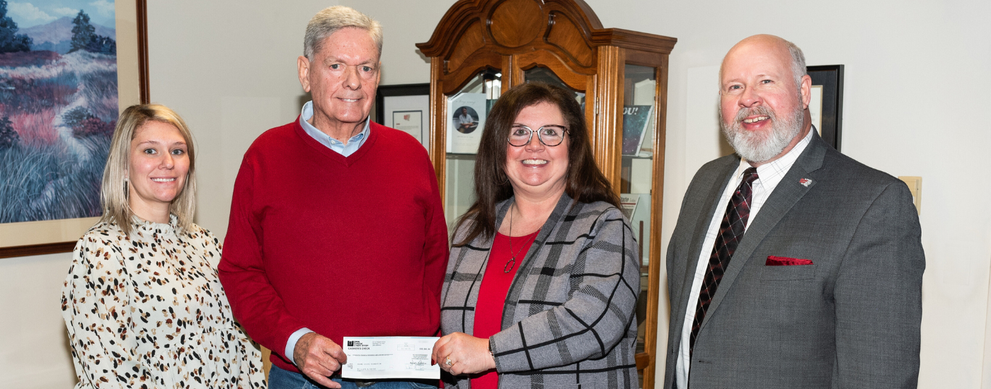 A group of people holding a check.