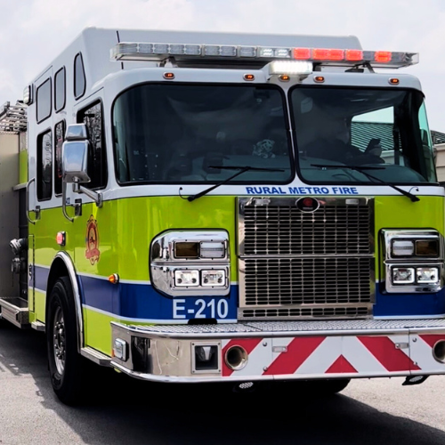 A Rural/Metro fire engine with lights flashing.