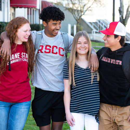 Four students walking on a college campus.
