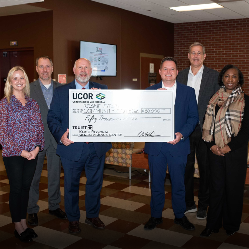A group of people holding a check for $50,000.