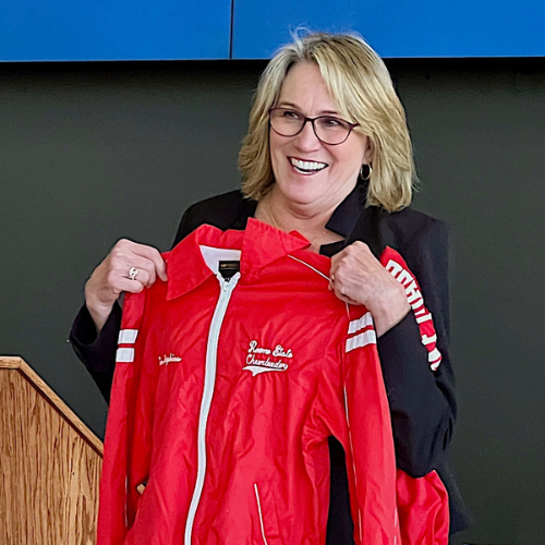 Kim Gheen holding a Roane State Cheerleading jacket.