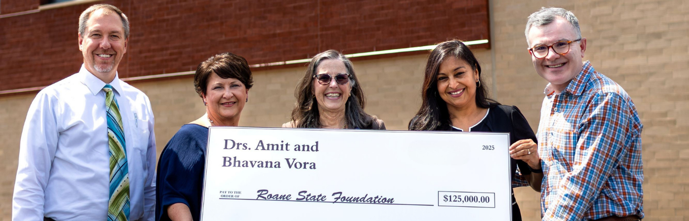 A group of people holding a large check for $125,000.