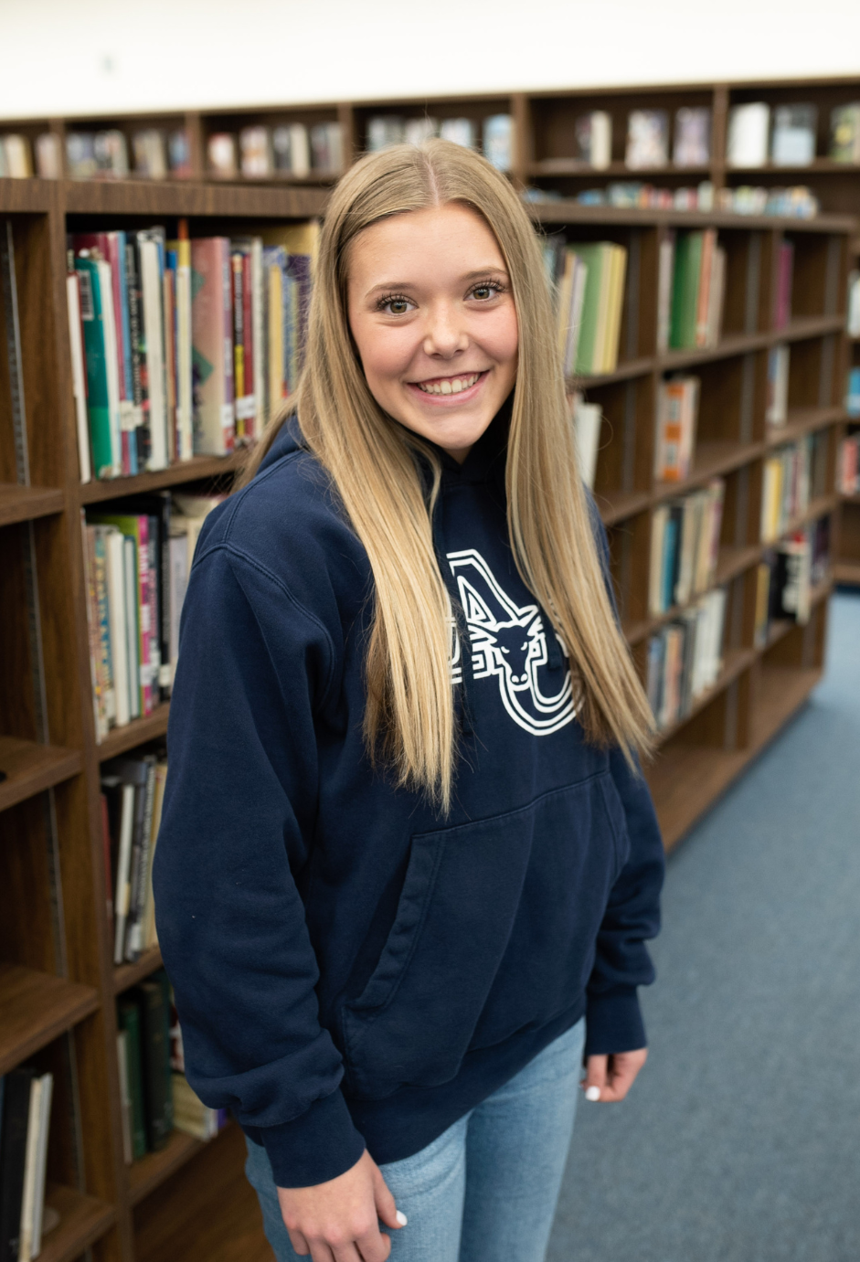 A girl standing in a library.