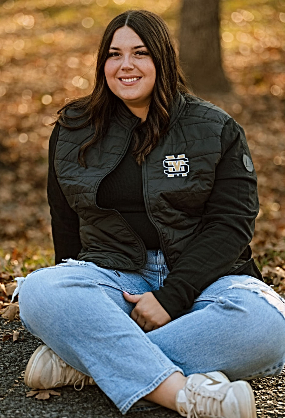 A student sitting outside in the fall.